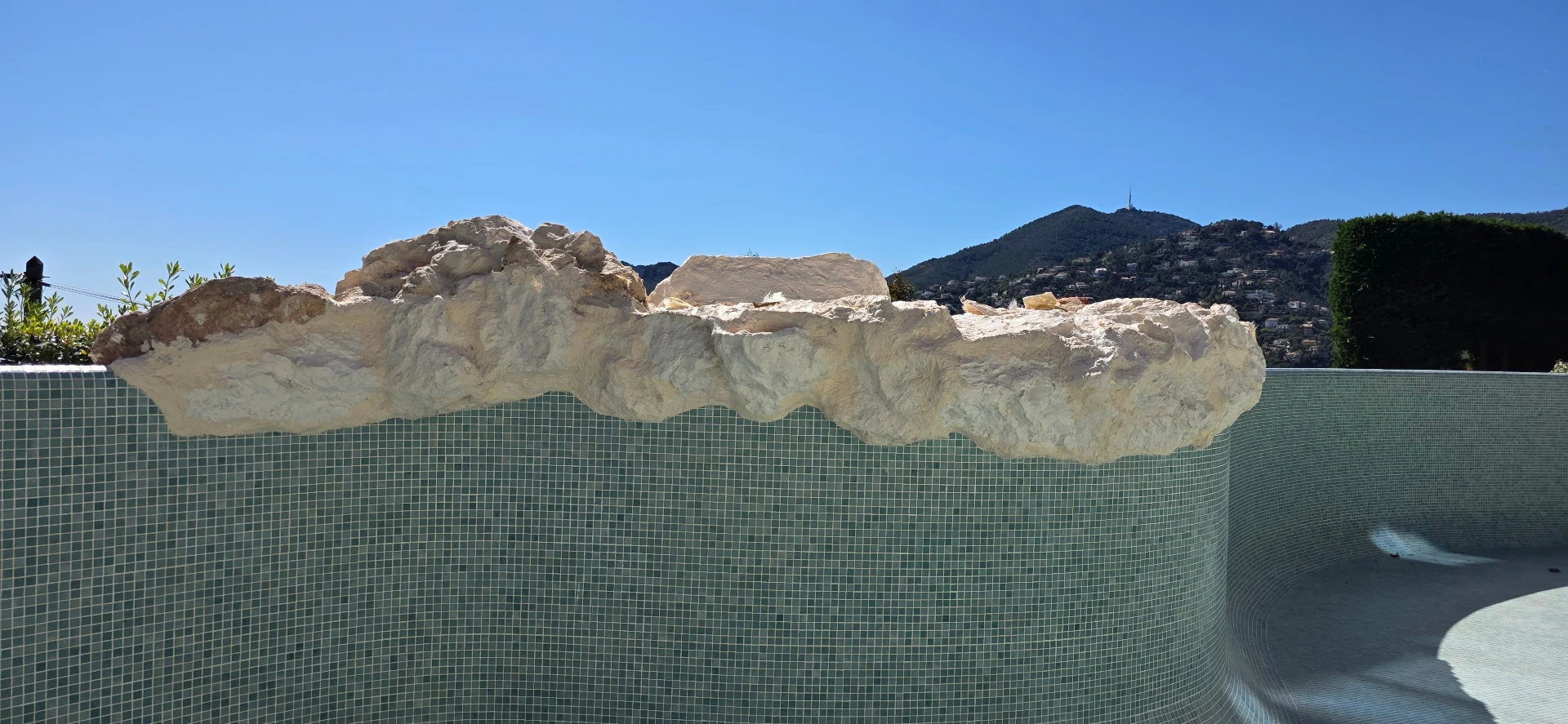 Faux rochers piscine polyester en cours de pose – décor rocheux sur mesure bord de piscine mosaïque Côte d'Azur