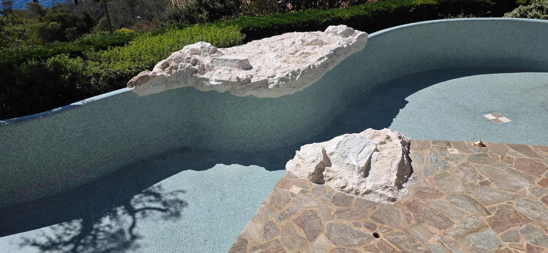Décor rocheux sur mesure piscine – faux rochers polyester bord bassin mosaïque et plage pierre naturelle