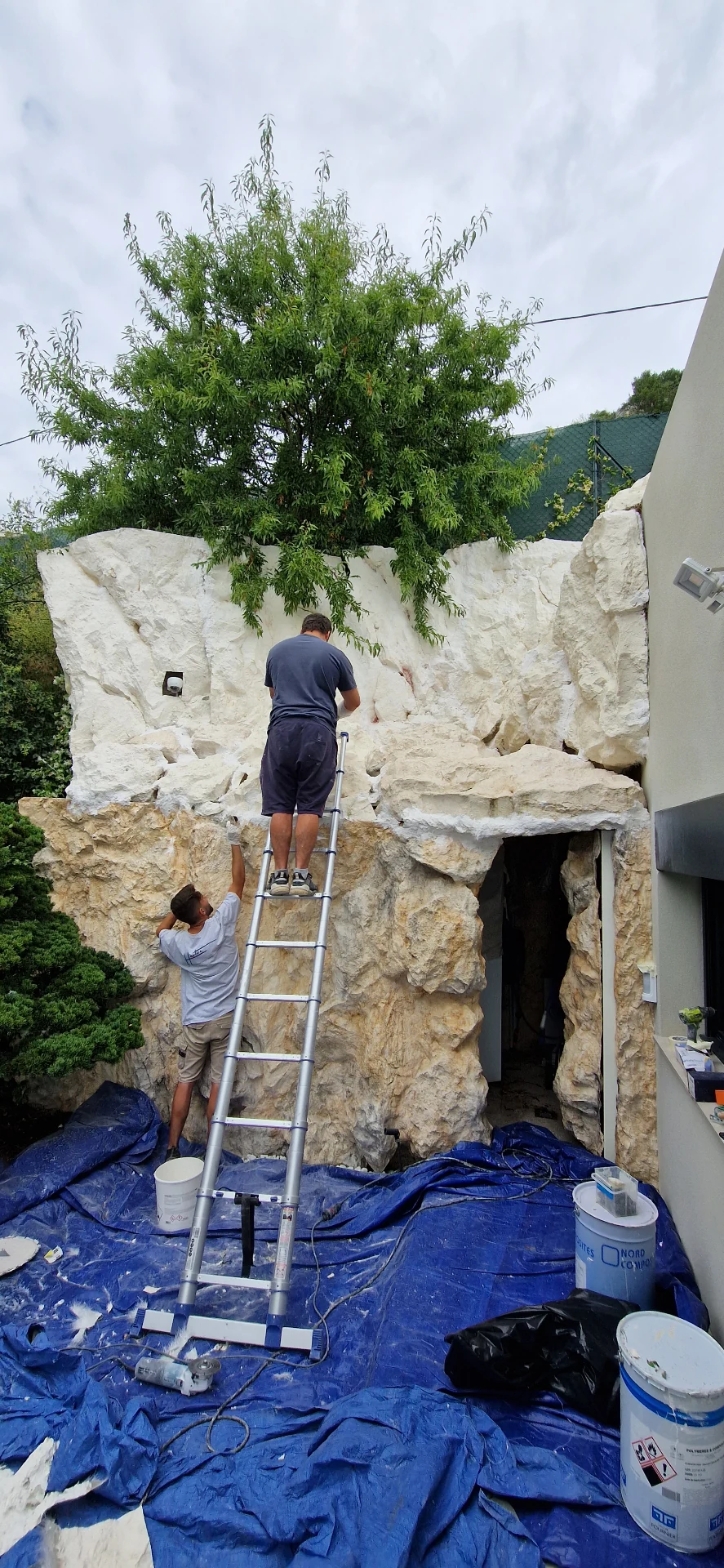 Pose des faux rochers en cours – artisans sur échelle